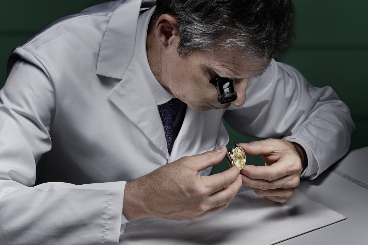 Watch repair specialist examining timepiece